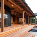 Diseño de terraza moderna con estructura de vigas de madera y suelo de traviesas de tren tratadas para exterior.