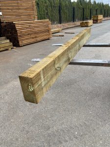 Gran stock de traviesas de madera ecológica tratadas en tono miel apiladas en nuestro almacén preparadas para envío.