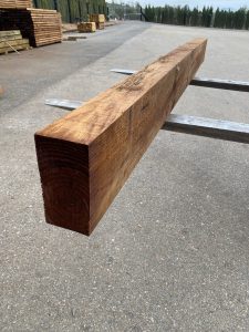 Traviesa de madera tratada en color marrón para decoración de jardines y proyectos de construcción exterior.