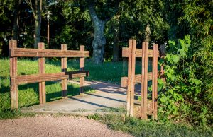Vallas de madera tratada para cerramientos de jardín y parques construidas con traviesas de tren rústicas.