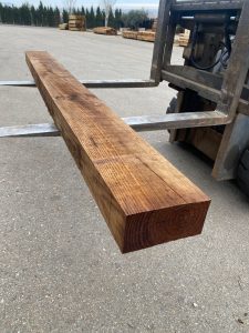 Detalle de viga de madera tratada en color marrón oscuro con acabado rústico para proyectos de construcción y paisajismo.